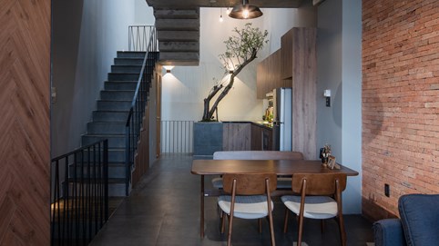 Nhà được bao phủ bởi nhiều lớp gạch thô và cây xanh