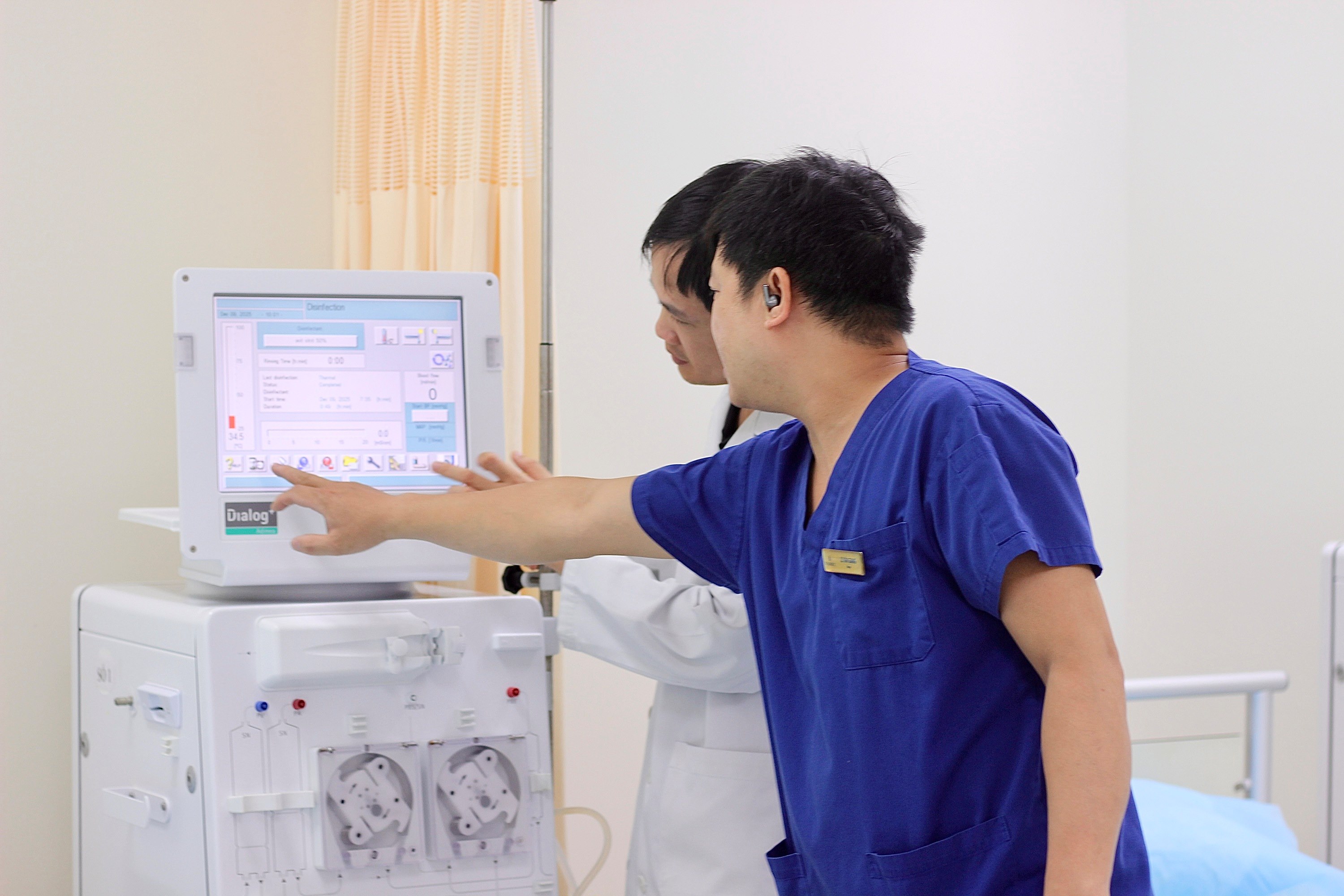 ThS.BSNT Mai Xu&acirc;n Đạt (&aacute;o trắng) thao t&aacute;c tr&ecirc;n m&aacute;y lọc m&aacute;u. &nbsp;