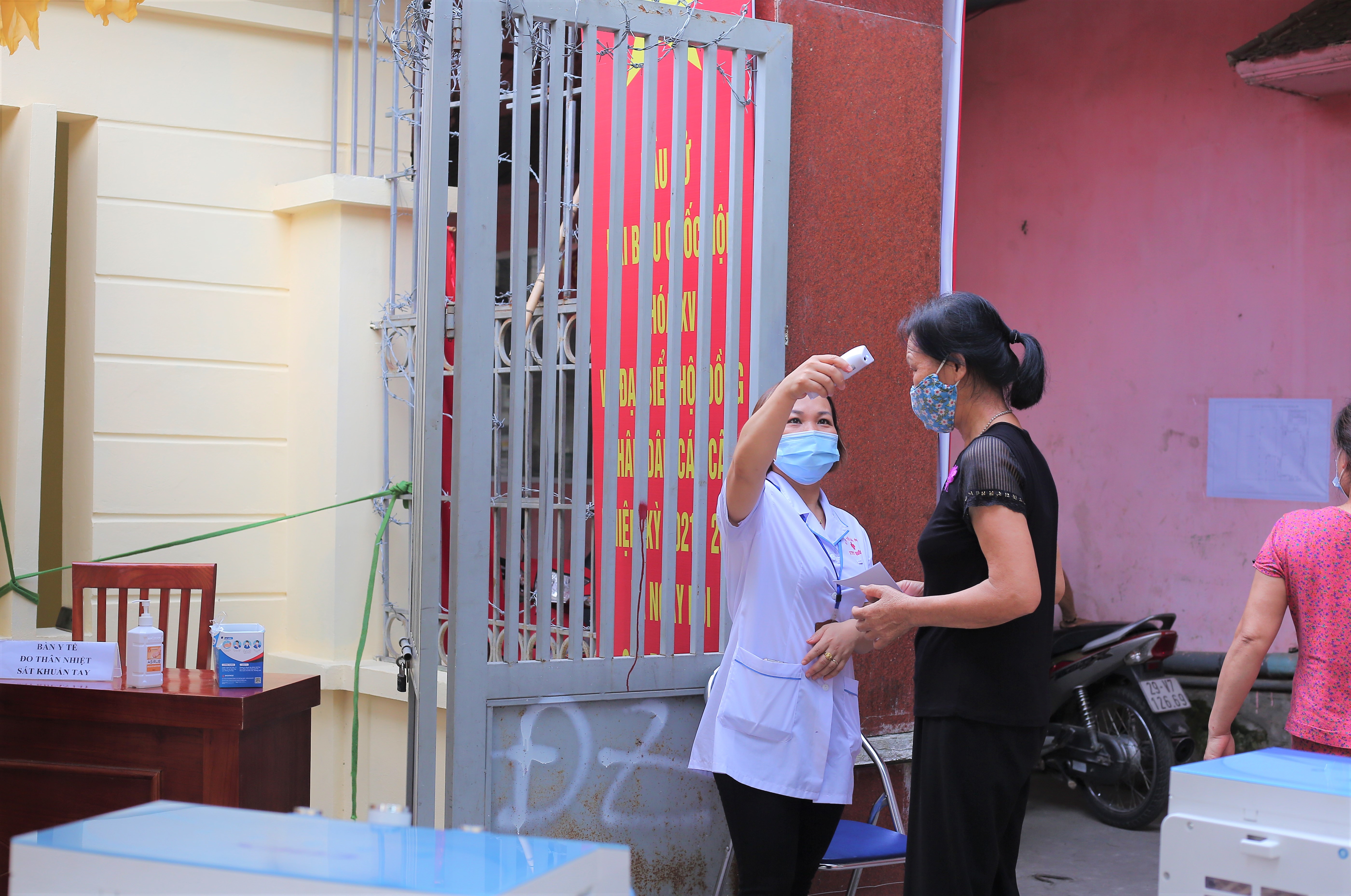 C&ocirc;ng t&aacute;c kiểm tra th&acirc;n nhiệt được thực hiện nghi&ecirc;m t&uacute;c tại điểm bầu cử quận Đống Đa. Ảnh: Huyền Mai