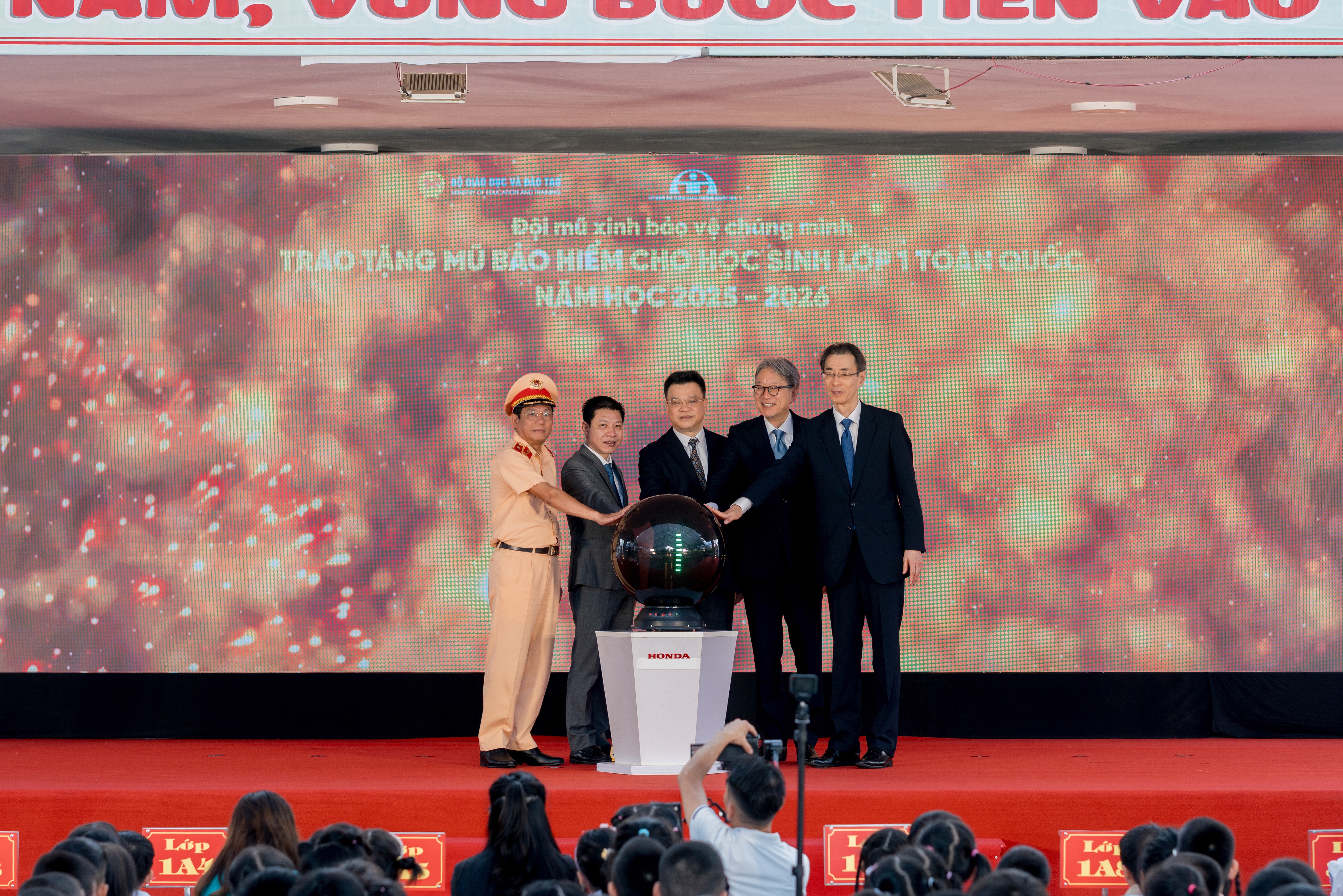 Các đại biểu thực hiện nghi thức phát động Chương trình Trao tặng mũ bảo hiểm cho học sinh lớp Một toàn quốc năm học 2025 – 2026 “Đội mũ xinh bảo vệ chúng mình”.