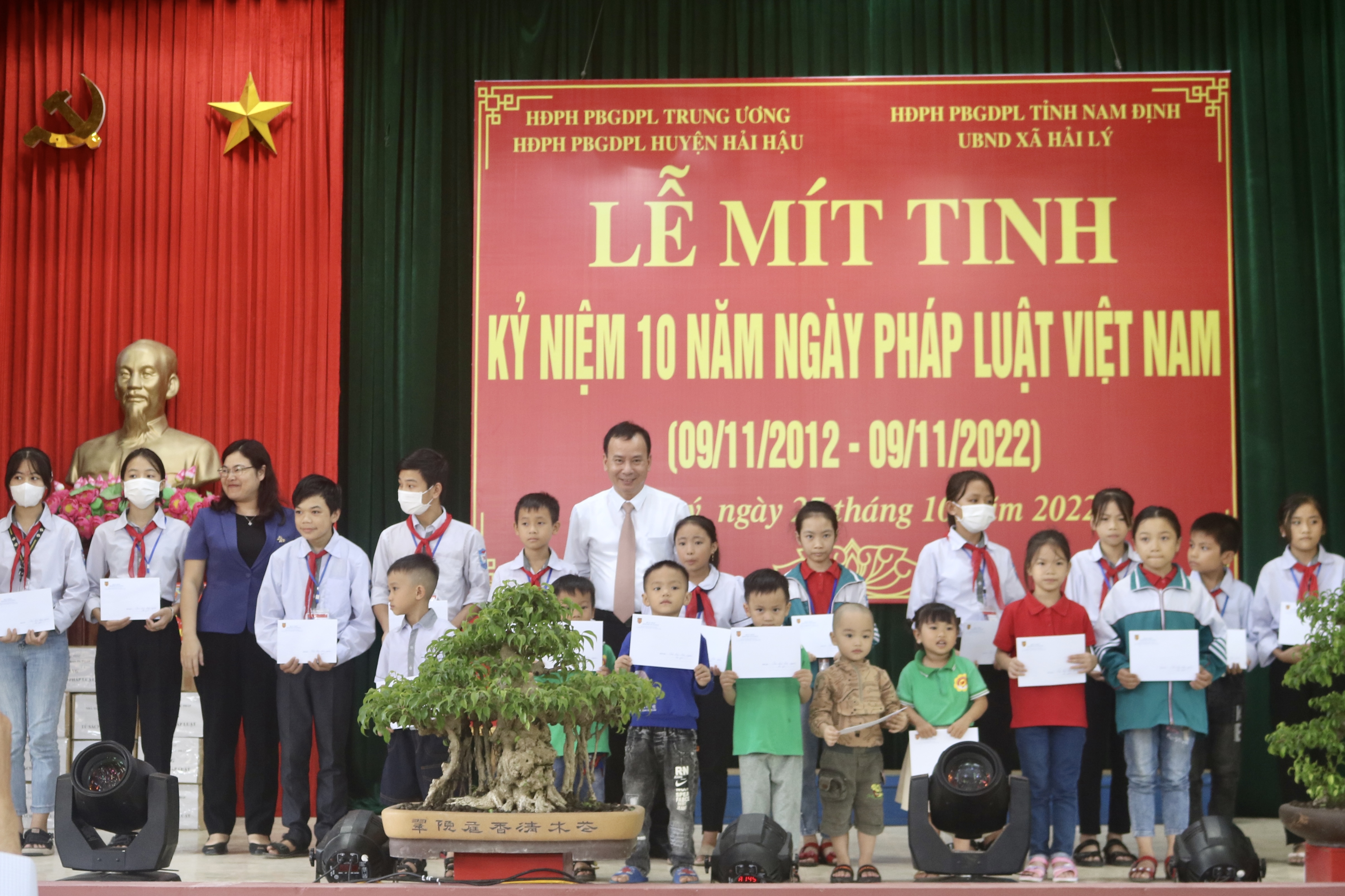 Ph&oacute; trưởng Ban D&acirc;n vận Trung ương Nguyễn Lam c&ugrave;ng Ph&oacute; Chủ tịch UBND tỉnh Nam Định H&agrave; Lan Anh trao qu&agrave; cho c&aacute;c học sinh ngh&egrave;o vượt kh&oacute;.
