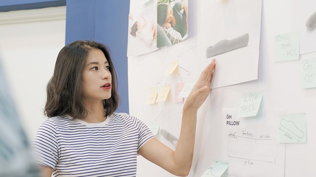 Đặng Th&ugrave;y Trang trao đổi c&ocirc;ng việc tại văn ph&ograve;ng.