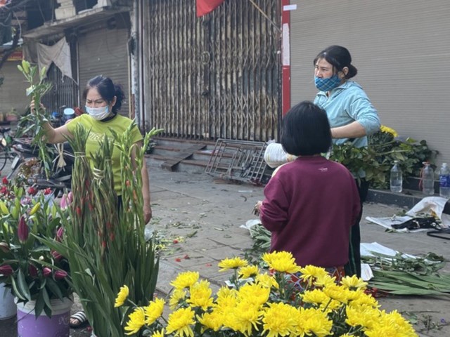 Kh&aacute;ch lựa hoa b&ecirc;n chợ Nguyễn C&ocirc;ng Trứ (H&agrave; Nội). Quầy h&agrave;ng trong chợ phần nhiều vẫn đ&oacute;ng cửa, c&aacute;c xe hoa thoải m&aacute;i đỗ vỉa h&egrave; bu&ocirc;n b&aacute;n