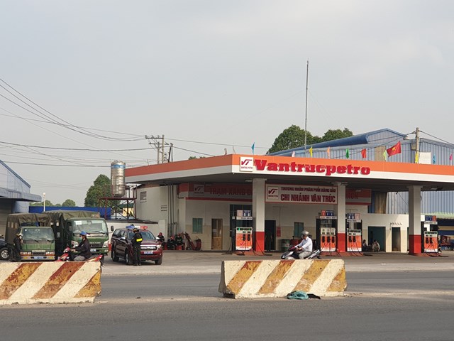 C&aacute;c xe biển xanh của C&ocirc;ng an tỉnh Đồng Nai phối hợp với c&ocirc;ng an địa phương để kh&aacute;m x&eacute;t c&acirc;y xăng tại B&igrave;nh Dương - Ảnh: B.S.