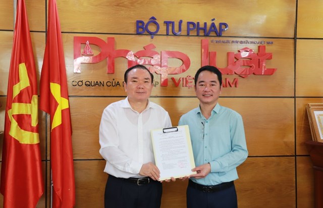 Ph&oacute; B&iacute; thư thường trực Đảng ủy Bộ Tư ph&aacute;p Nguyễn Kim Tinh trao Quyết định cho đồng ch&iacute; Vũ Ho&agrave;i Nam, Tổng Bi&ecirc;n tập B&aacute;o PLVN.