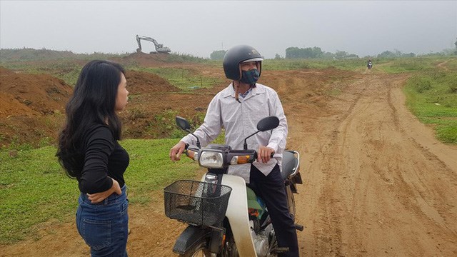 Một người d&acirc;n địa phương (người ngồi tr&ecirc;n xe m&aacute;y) trao đổi với kh&aacute;ch t&igrave;m mua đất