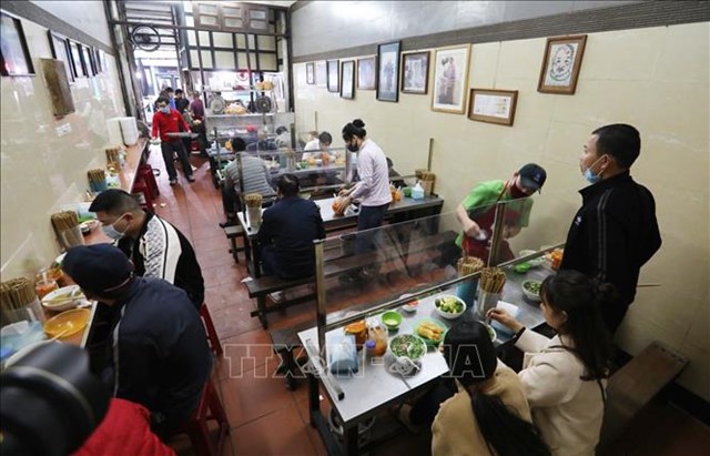 H&agrave;ng phở tr&ecirc;n phố L&ograve; Đ&uacute;c lắp tấm chắn giữa c&aacute;c vị tr&iacute; ngồi đảm bảo ph&ograve;ng chống dịch. Ảnh tư liệu: Th&agrave;nh Đạt/TTXVN &nbsp;