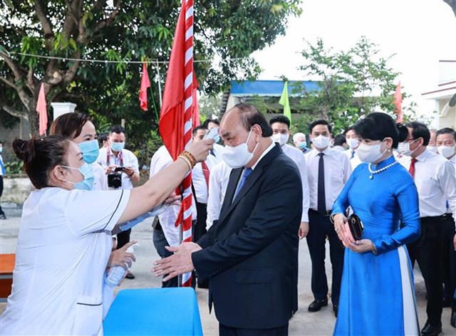 Chủ tịch nước Nguyễn Xu&acirc;n Ph&uacute;c rửa tay s&aacute;t khuẩn v&agrave; được đo kiểm tra th&acirc;n nhiệt tại khu vực bỏ phiếu số 041, đơn vị bầu cử số 10 thuộc thị trấn Củ Chi. Ảnh: Thống Nhất/TTXVN &nbsp;