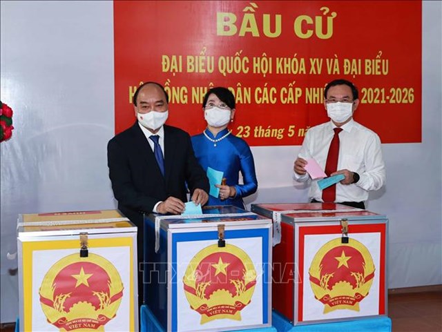 Chủ tịch nước Nguyễn Xu&acirc;n Ph&uacute;c c&ugrave;ng Phu nh&acirc;n v&agrave; B&iacute; thư Th&agrave;nh uỷ TP Hồ Ch&iacute; Minh Nguyễn Văn N&ecirc;n c&ugrave;ng c&aacute;c cử tri bỏ phiếu bầu đại biểu Quốc hội kh&oacute;a XV v&agrave; Hội đồng nh&acirc;n d&acirc;n c&aacute;c cấp nhiệm kỳ 2021-2026. Ảnh: Thống Nhất/TTXVN &nbsp;