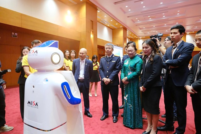 C&aacute;c đại biểu trải nghiệm tương t&aacute;c với robot trả lời, tư vấn tự động về thuế - Ảnh: VGP/HT