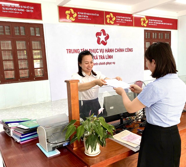 Cán bộ Trung tâm hành chính công xã Trà Lĩnh (Cao Bằng) hỗ trợ giúp người dân đến đến làm thủ tục cấp bản sao trích lục hộ tịch (Ảnh: Lê Hanh)