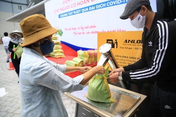 Nhiều người lao động mất việc v&igrave; đại dịch, đ&atilde; sống dưới mức tối thiểu v&agrave; sống nhờ bằng sự hỗ trợ của cộng đồng. Trong ảnh: người d&acirc;n nhận gạo từ ATM gạo ở TPHCM. Ảnh: Tư liệu TBKTSG.