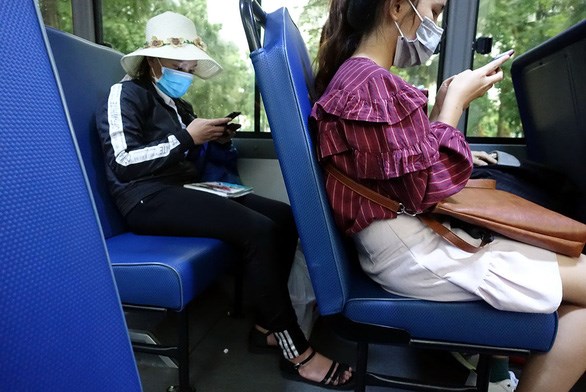 Người phụ nữ (b&ecirc;n tr&aacute;i) li&ecirc;n tục thực hiện c&aacute;c cuộc gọi mời mua đất nền khi đang tr&ecirc;n một chuyến xe bu&yacute;t số 64&nbsp;