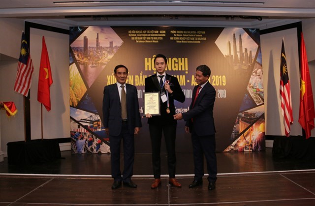 CEO Nguyễn Thế Trung được &ocirc;ng L&ecirc; C&ocirc;ng Phụng (tr&aacute;i) - nguy&ecirc;n Thứ trưởng thường trực Bộ Ngoại giao Việt Nam, Chủ tịch Hội hữu nghị v&agrave; hợp t&aacute;c Việt Nam - ASEAN, v&agrave; &ocirc;ng L&ecirc; Qu&yacute; Quỳnh (phải) - Đại sứ Việt Nam tại Malaysia trao giải thưởng.