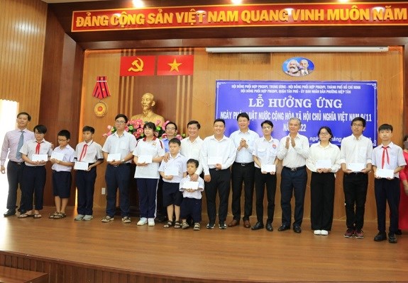 Thứ trưởng Nguyễn Thanh Tịnh, Ph&oacute; Chủ tịch UBND TPHCM Ng&ocirc; Minh Ch&acirc;u c&ugrave;ng c&aacute;c l&atilde;nh đạo Sở Tư ph&aacute;p v&agrave; l&atilde;nh đạo phường Hiệp T&acirc;n trao qu&agrave; cho sinh vi&ecirc;n, học sinh c&oacute; ho&agrave;n cảnh kh&oacute; khăn