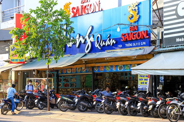 H&igrave;nh ảnh thương hiệu của một h&atilde;ng bia tr&ecirc;n bảng hiệu qu&aacute;n nhậu.