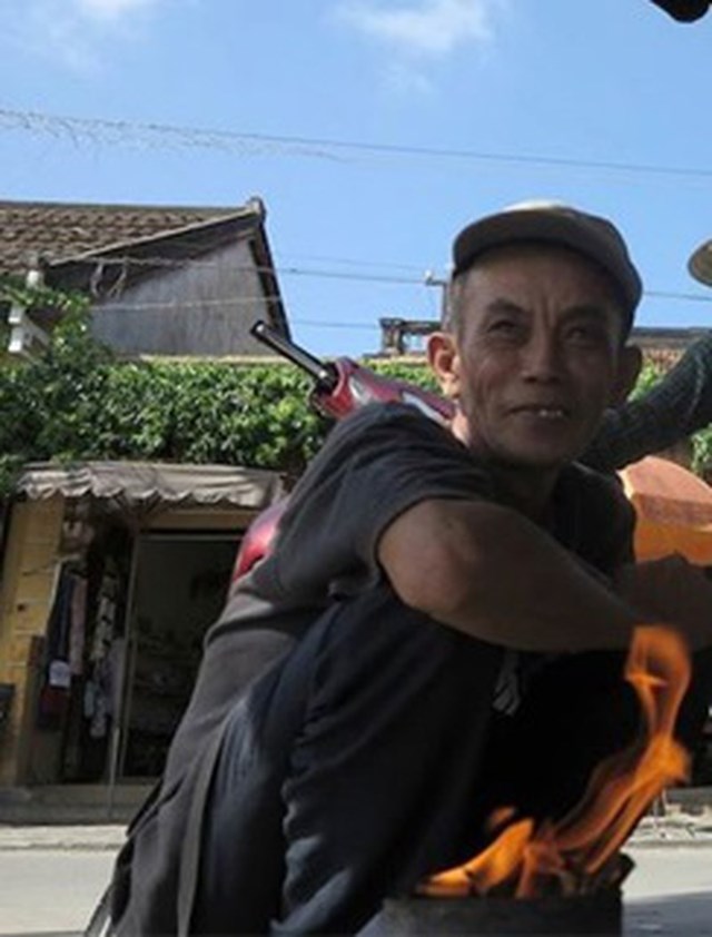 &nbsp;&Ocirc;ng Nguyễn Văn Sỹ một người h&agrave;nh nghề v&aacute; &aacute;o mưa hiếm hoi tại phố cổ Hội An.&nbsp;