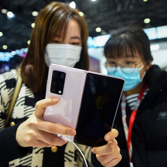 Kh&aacute;ch h&agrave;ng trải nghi&ecirc;m t&iacute;nh năng điện thoại&nbsp;Mate X2 của Huawei. Ảnh: WSJ