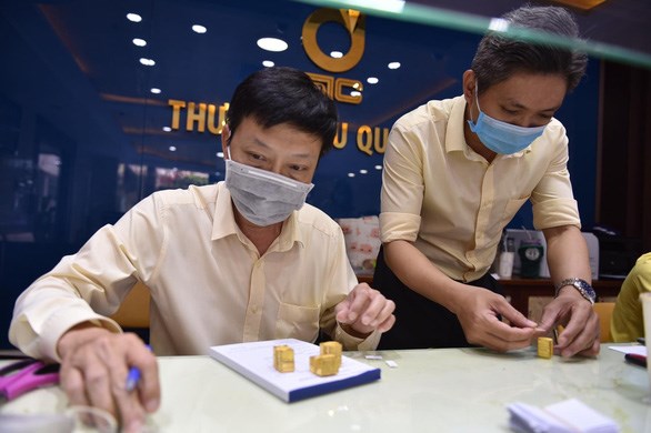 Người giữ v&agrave;ng đ&atilde; đổ x&ocirc; b&aacute;n khi thấy gi&aacute; v&agrave;ng giảm qu&aacute; nhanh. Trong h&igrave;nh l&agrave; v&agrave;ng C&ocirc;ng ty SJC mua của người d&acirc;n được cắt bao b&igrave; để &eacute;p lại - Ảnh: NGỌC PHƯỢNG
