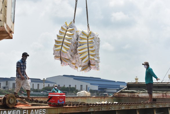 Một doanh nghiệp đưa gạo l&ecirc;n t&agrave;u để xuất khẩu - Ảnh: BỬU ĐẤU