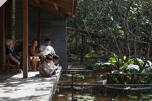 Khu vực hi&ecirc;n nh&agrave; ngăn c&aacute;ch hồ nước với khu vực sinh hoạt chung của ng&ocirc;i nh&agrave;. Đ&acirc;y l&agrave; nơi&nbsp;cả gia đ&igrave;nh nhỏ qu&acirc;y quần b&ecirc;n nhau c&ugrave;ng tr&ograve; chuyện, thư gi&atilde;n, tận hưởng sự ri&ecirc;ng tư v&agrave; bầu kh&ocirc;ng kh&iacute; trong l&agrave;nh b&ecirc;n trong khu vườn đầy hoa bưởi.&nbsp;