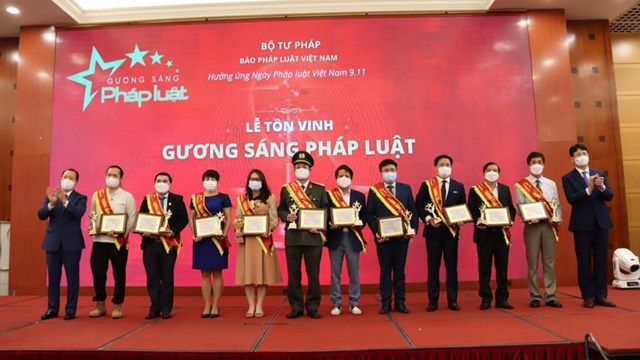 Thứ trưởng Nguyễn Thanh Tịnh (ngo&agrave;i c&ugrave;ng b&igrave;a phải) v&agrave; Tổng Bi&ecirc;n tập Đ&agrave;o Văn Hội (ngo&agrave;i c&ugrave;ng b&igrave;a tr&aacute;i) Giấy chứng nhận của Chương tr&igrave;nh cho c&aacute;c Gương s&aacute;ng Ph&aacute;p luật 2021.
