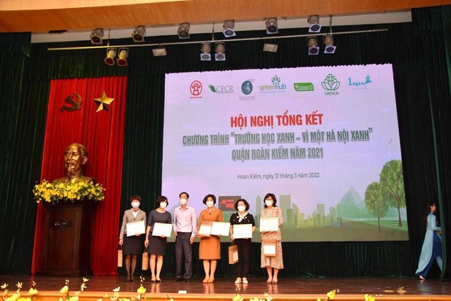 Nh&agrave; gi&aacute;o Trần Thị B&iacute;ch Li&ecirc;n &ndash; B&iacute; thư chi bộ, Hiệu trưởng trường Tiểu học Tr&agrave;ng An (đứng thứ ba từ tr&aacute;i sang) thay mặt nh&agrave; trường nhận giấy chứng nhận đạt th&agrave;nh t&iacute;ch Xuất sắc chương tr&igrave;nh &ldquo;X&acirc;y dựng trường học xanh - V&igrave; một H&agrave; Nội xanh&rdquo; tr&ecirc;n địa b&agrave;n quận Ho&agrave;n Kiếm.