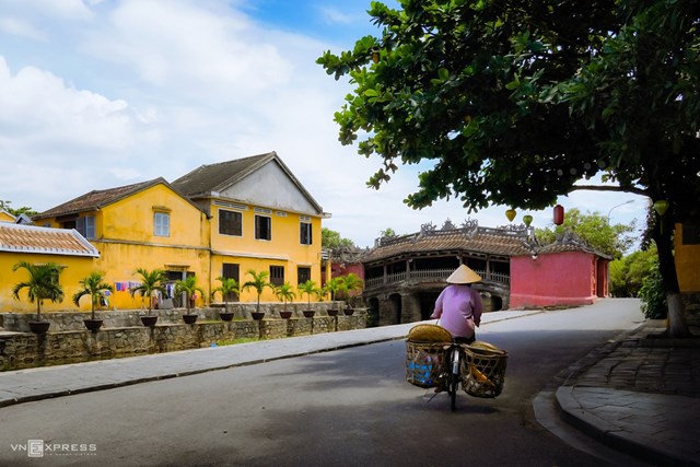 Một phụ nữ đạp xe về nh&agrave; khi b&aacute;n xong, chạy ngang qua khu vực ch&ugrave;a Cầu kh&ocirc;ng b&oacute;ng người l&uacute;c hơn 10h s&aacute;ng 6/8.