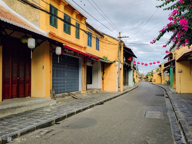 Hội An đặc trưng với những mảng tường v&agrave;ng v&agrave; được điểm xuyết m&agrave;u trắng t&iacute;m hồng v&agrave;o m&ugrave;a hoa giấy nở. Khung cảnh l&uacute;c n&agrave;y y&ecirc;n b&igrave;nh v&agrave; con người sống chậm do Covid-19, ảnh được chụp tr&ecirc;n đường Trần Ph&uacute;.