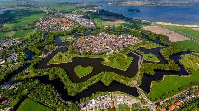 &nbsp;Nằm c&aacute;ch thủ đ&ocirc; Amsterdam của H&agrave; Lan khoảng 20km về ph&iacute;a Đ&ocirc;ng,&nbsp;Naarden được đ&aacute;nh gi&aacute; l&agrave; th&agrave;nh phố h&igrave;nh ng&ocirc;i sao ấn tượng nhất ở xử sở hoa tulip. Th&agrave;nh phố được bao quanh bởi hai v&ograve;ng h&agrave;o nước c&ugrave;ng với h&agrave;ng c&acirc;y v&agrave; thảm cỏ tạo th&agrave;nh phần "c&aacute;nh sao" ho&agrave;n hảo&nbsp;Một trong những địa điểm tham quan nổi tiếng ở đ&acirc;y phải kể đến Bảo t&agrave;ng ph&aacute;o đ&agrave;i H&agrave; Lan.