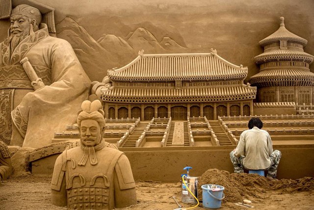 Những nghệ sĩ đầu tư rất nhiều c&ocirc;ng sức để tạo ra c&aacute;c kiệt t&aacute;c đơn sắc từ h&agrave;ng triệu hạt c&aacute;t. Họ tỉ mỉ tạo h&igrave;nh từ những chi tiết nhỏ nhất, c&aacute;ch l&aacute;t gạch trang tr&iacute; đến &ocirc; cửa sổ, cầu thang...để m&ocirc; phỏng c&aacute;c c&ocirc;ng tr&igrave;nh kiến tr&uacute;c phức tạp. Trong ảnh, nh&agrave; đi&ecirc;u khắc c&aacute;t Zhang Weikang thực hiện t&aacute;c phẩm về c&aacute;c di t&iacute;ch lịch sử ở Trung Quốc cho triển l&atilde;m nghệ thuật c&aacute;t Yokohama tại Nhật Bản năm 2014.