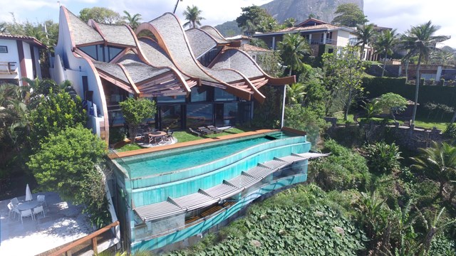  Ngoài ra phía trong của công trình là khu vực hồ bơi ngoài trời hướng về khu vườn nhỏ xanh mát. Thiết kế hồ bơi cũng có độ nghiêng và uốn lượn giống như một con sóng nhỏ.