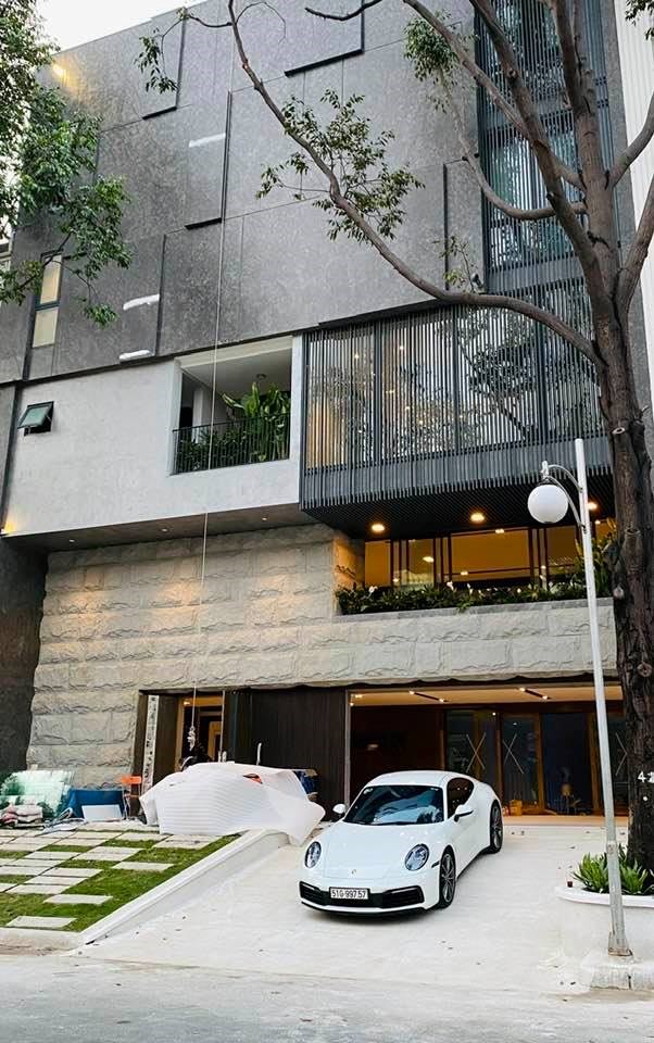 Ngôi nhà được thiết kế khá độc đáo với mặt tiền có đường dốc thoai thoải để dễ dàng di chuyển những chiếc xe gầm thấp vào gara ngay tầng 1. Phong cách này tương tự với căn nhà màu trắng trước đây ở quận 7 của nam doanh nhân.