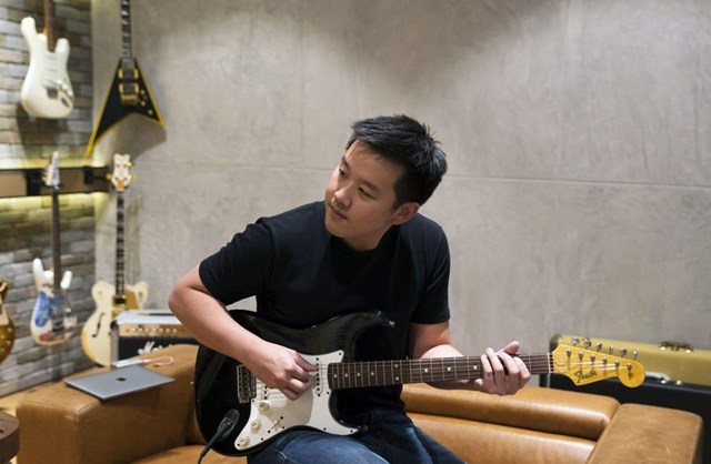 Kuok Meng Ru chơi ghi-ta trong một cửa h&agrave;ng ghi-ta Swee Lee ở Singapore. Ảnh: Bloomberg.