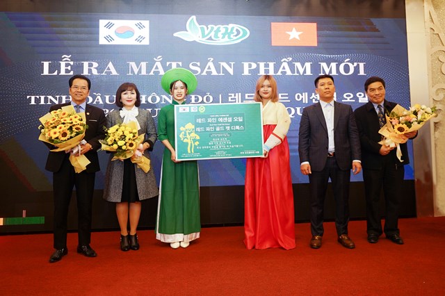 Các khách mời chụp ảnh với sản phẩm tinh dầu thông đỏ trong buổi lễ ra mắt