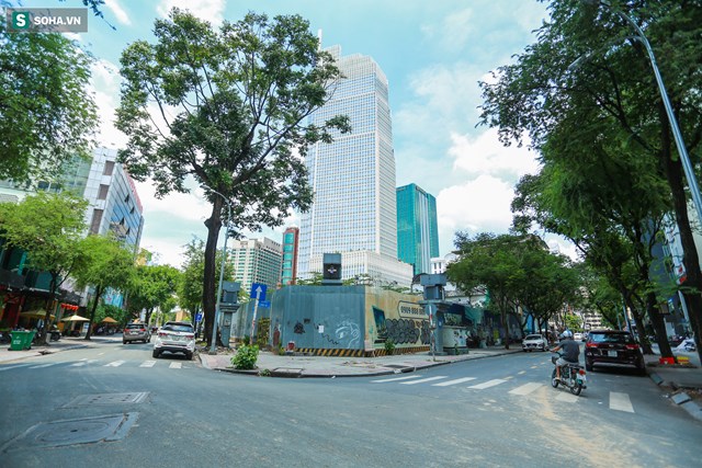 Khu đất được r&agrave;o chắn nhiều năm nay, b&ecirc;n trong cỏ mọc um t&ugrave;m. Nh&igrave;n từ hướng ng&atilde; tư Thi S&aacute;ch - Đ&ocirc;ng Du c&oacute; thể thấy cao ốc Vietcombank Tower b&ecirc;n cạnh.