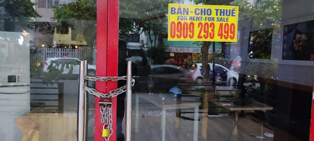 Một cửa tiệm cửa đ&oacute;ng then c&agrave;i nhưng đồ đạc vẫn chưa kịp dọn ra khỏi qu&aacute;n.&nbsp;